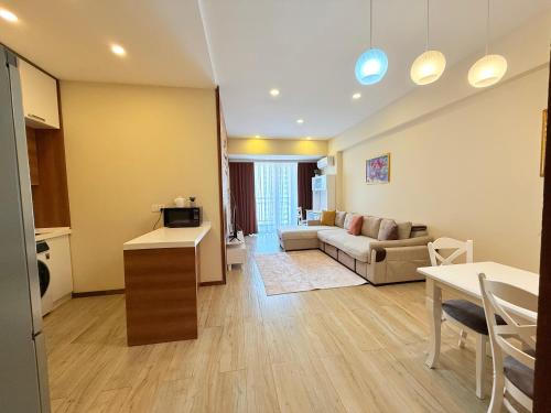 a living room with a couch and a table at Park Azure 0414 in Baku
