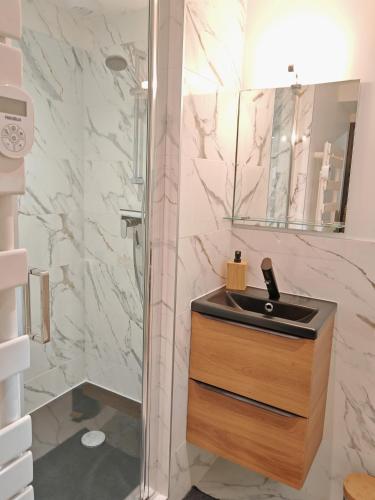 une salle de bain avec un lavabo et une douche dans l'établissement Le domaine de la gentilhommière située entre Bayeux et Arromanches les Bains, à Manvieux