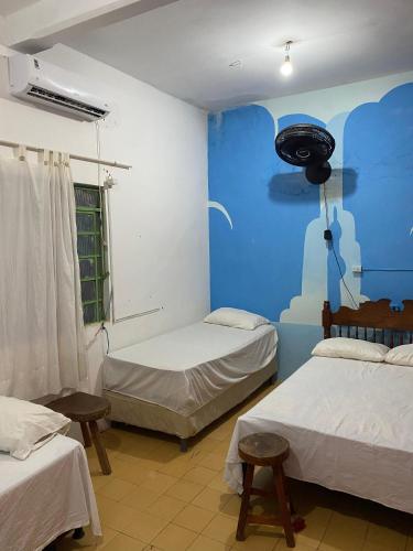 a room with two beds and a blue wall at Hostel e Camping da Cris in Carolina