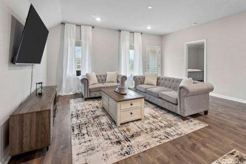 a living room with two couches and a tv at 4 Bedroom home with Hot Tub in Lake Charles La in Lake Charles