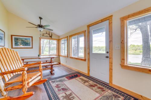 a living room with a table and chairs and windows at Hatfield Family Home on Lake Arbutus Boat and Hike in Neillsville