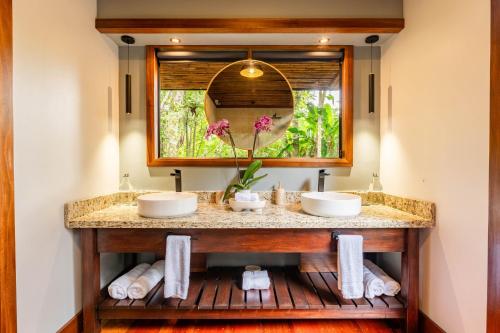 Un baño con dos lavabos y un espejo. en Secret Bungalows Lechu, en Fortuna