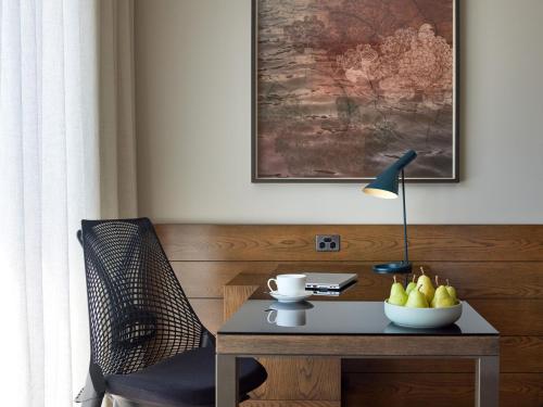 a table with a lamp and a bowl of fruit on it at Pan Pacific Melbourne in Melbourne