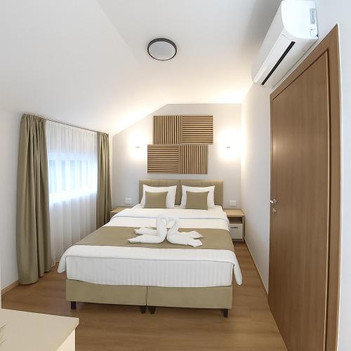 a bedroom with a bed with two towels on it at Royal Apartments in Bitola