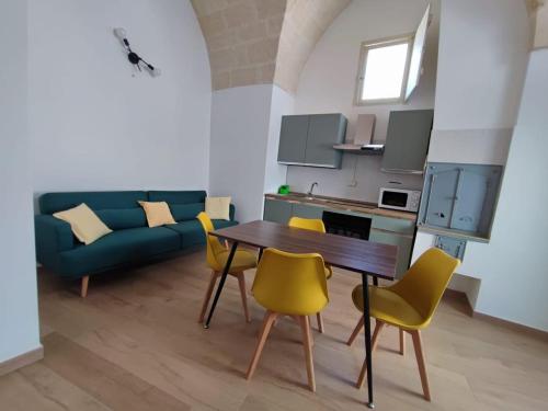 a living room with a table and yellow chairs at Appartamento al Bommino in Massafra