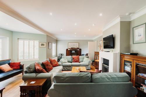 a living room with two couches and a tv at Little Orchard - Cowes in Isle of Wight
