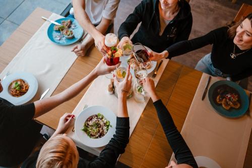a group of people sitting around a table drinking wine at Hotel Lesana in Vysoké Tatry