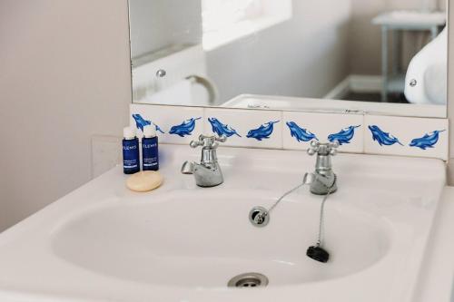 a bathroom sink with two faucets and a mirror at Little Orchard - Cowes in Isle of Wight