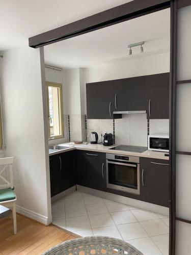 a kitchen with black and white cabinets and appliances at French Welcome in Paris