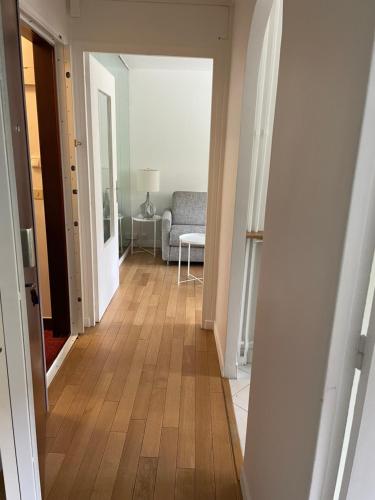 a hallway with a room with a couch and a wooden floor at French Welcome in Paris