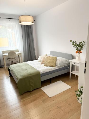 a bedroom with a bed in a white room at Apartament Nikola in Władysławowo
