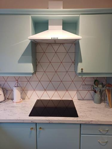 a kitchen with a hood over a kitchen counter at Bright & Cozy Home in Knocknacarra in Galway