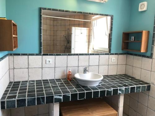 une salle de bain avec un lavabo et un miroir dans l'établissement Le Mirador, à Béziers