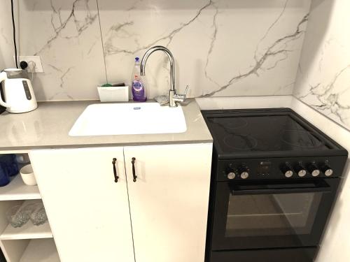 a kitchen with a sink and a black stove at Casa Gilboa Nirvana Suite נופש בגלבוע in Gan Ner