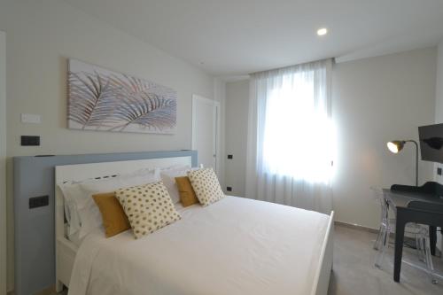 a white bed with pillows and a desk in a bedroom at CIVICO 8 Reggio Emilia in Reggio Emilia