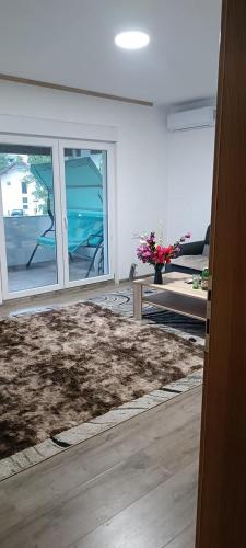 a living room with a rug and a couch and windows at Villa elhalabi in Ilidza