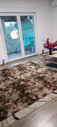 a brown furry rug in a living room with a table at Villa elhalabi in Ilidza