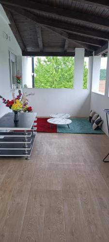 a living room with a table and flowers in a room at Villa elhalabi in Ilidza