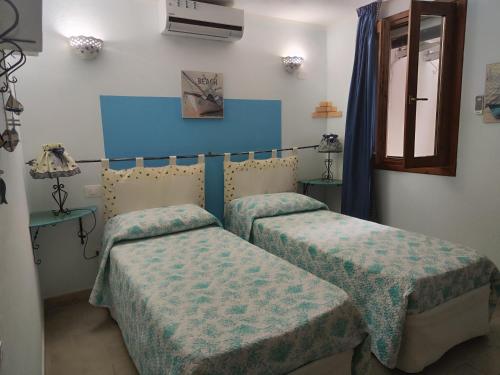 two beds in a room with blue and white walls at La Pirata Capitana in Costa degli Angeli
