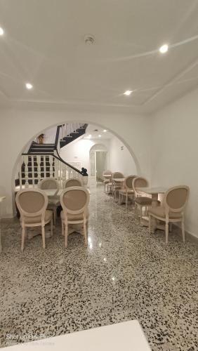 a room with chairs and tables and a staircase at Sea Esta Guest House in Mellieħa