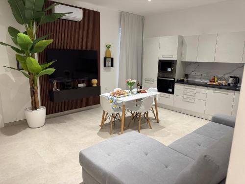 a living room with a table and a kitchen at The White Balcony in Il-Gżira