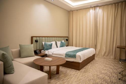 a hotel room with a bed and a couch at فندف ألان للشقق الفندقية in Hail