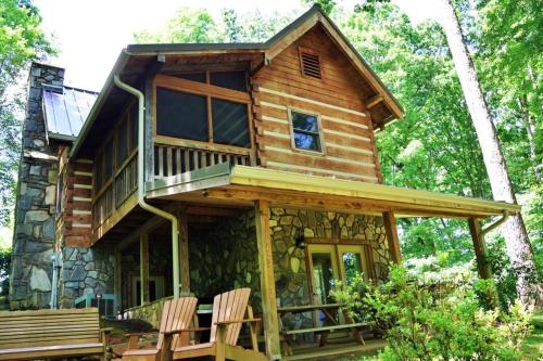 a cabin in the woods with a deck and chairs at The Ridge in Whittier