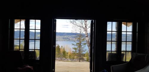 an open door with a view of a lake at Mjøshytte in Stange
