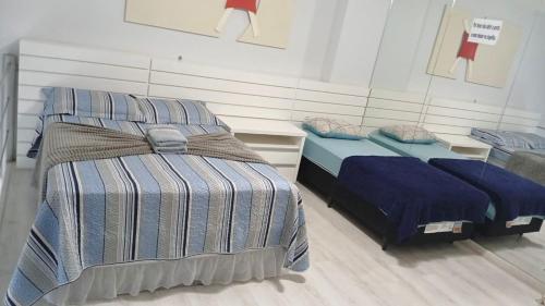 a room with two beds in a roomthritisthritisthritisthritisthritisthritisthritisthritis at Saint Sebastian Flat 213 - Com Hidro! até 4 pessoas, Duplex, no centro in Jaraguá do Sul