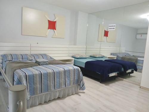 a bedroom with two beds and a painting on the wall at Saint Sebastian Flat 213 - Com Hidro! até 4 pessoas, Duplex, no centro in Jaraguá do Sul
