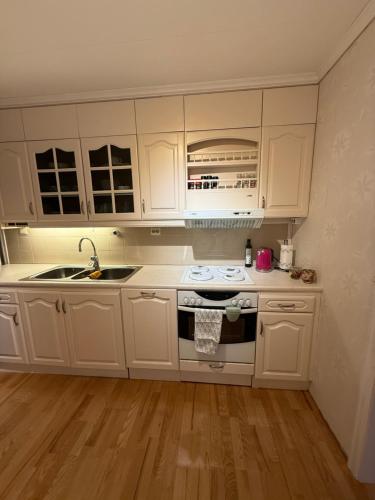 a kitchen with white cabinets and a stove top oven at Stryn Central View in Stryn
