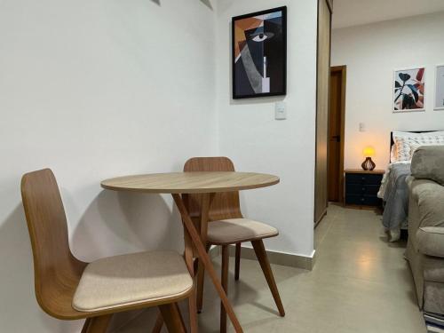 a room with a table and two chairs and a bed at Studio in front of USP in São Carlos