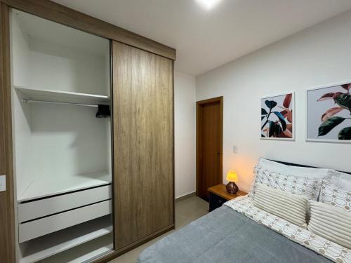a bedroom with a bed and a glass closet at Studio in front of USP in São Carlos