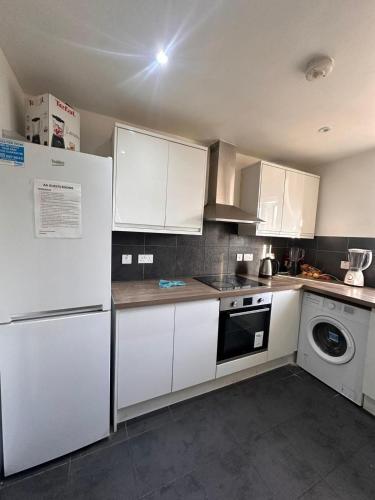 a kitchen with white appliances and white cabinets at Eastgate Ensuite Room in London