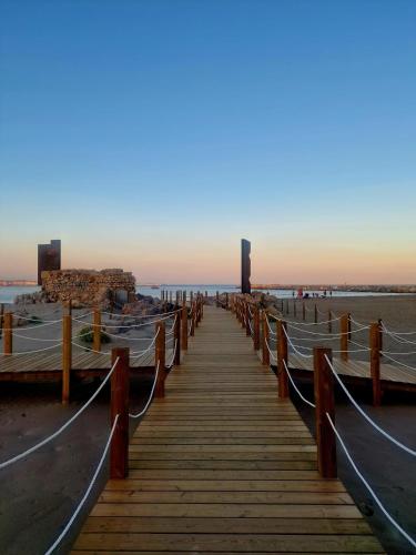 a wooden boardwalk on the beach at sunset at MASIA EN COSTA DORADA y CLIMATIZADA in Reus