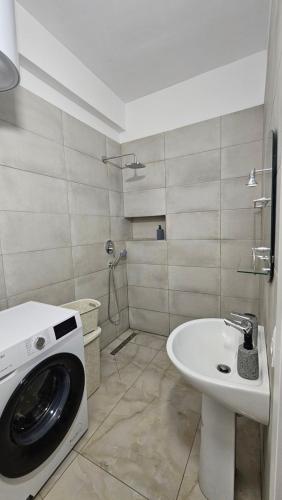 a bathroom with a washing machine and a sink at 3 Modern Apartments for big groups or families in Orikum
