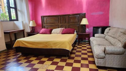 a bedroom with a bed and a couch at Hotel Sautto in San Miguel de Allende