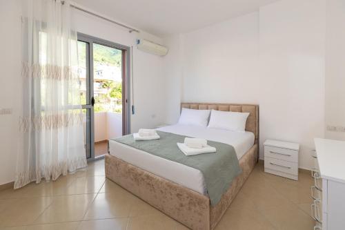 Un dormitorio blanco con una cama y una ventana. en Sea View Luxury Apartments, en Vlorë