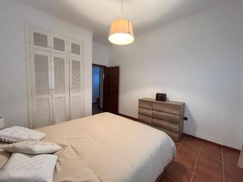 a bedroom with a large bed and a dresser at Cabo garden in Cabo Negro