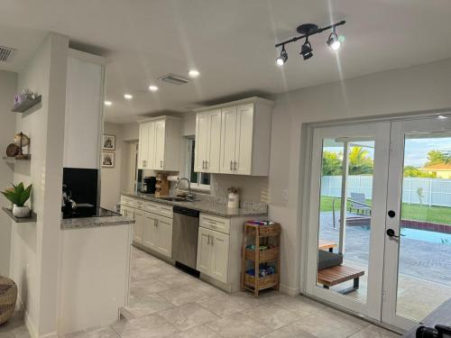 a kitchen with white cabinets and a view of a pool at Pool house in Englewood in Englewood