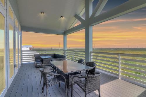 a table and chairs on a porch with a view of the ocean at BeachHouse Bliss in Padre Island