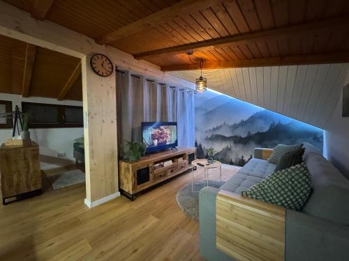 a living room with a couch and a tv at Bleibach Chalet in Gutach im Breisgau
