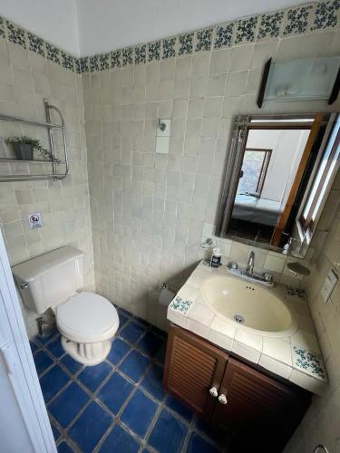a bathroom with a toilet and a sink and a mirror at Casa Colibri, residencia de descanso in Xochitepec