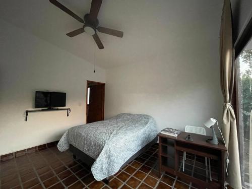 a bedroom with a bed and a ceiling fan at Casa Colibri, residencia de descanso in Xochitepec