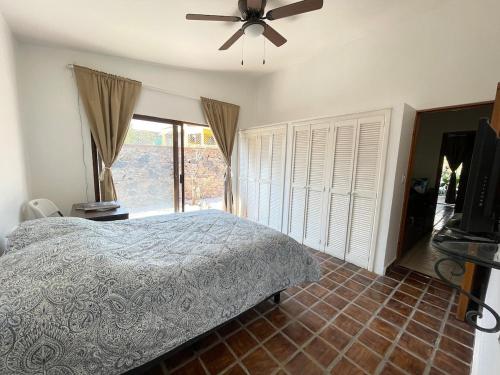 a bedroom with a bed and a ceiling fan at Casa Colibri, residencia de descanso in Xochitepec