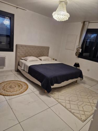 une chambre avec un grand lit avec une couverture bleue dans l'établissement Maison paisible et spacieuse, à Sorgues