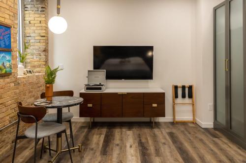 a living room with a tv and a table and chairs at Spacious 2 King Suites - The Finnley Hotel in Grand Rapids