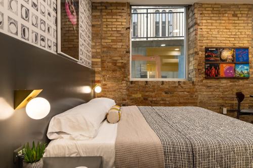 a bedroom with a bed and a brick wall at Spacious 2 King Suites - The Finnley Hotel in Grand Rapids