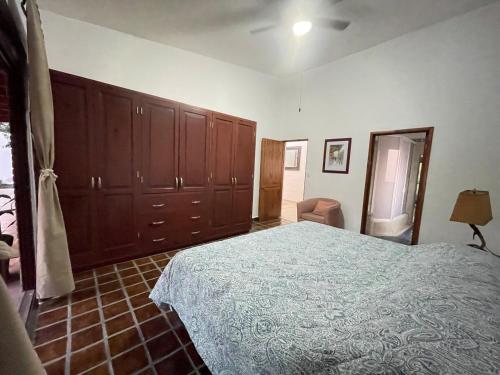 a bedroom with a large bed and wooden cabinets at Casa Colibri, residencia de descanso in Xochitepec