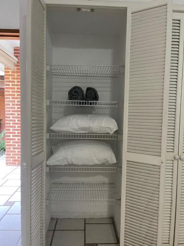a closet with white shelves and white pillows at Casa Colibri, residencia de descanso in Xochitepec